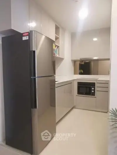 Modern kitchen with sleek cabinetry and stainless steel appliances in a compact layout.