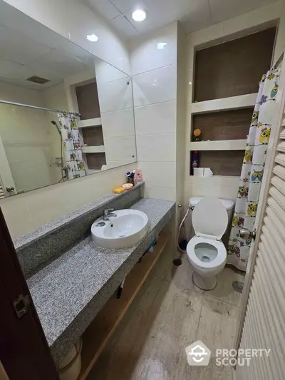 Modern bathroom with granite countertop and spacious mirror