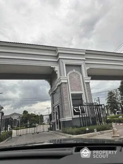 Elegant gated entrance of luxury residential community with classic architectural design.