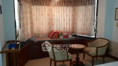 Charming living room with cozy seating and a window nook, perfect for relaxation.