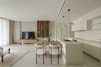 Modern open-plan living room and kitchen with sleek design and neutral tones.