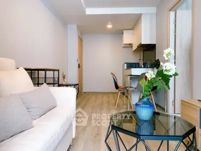 Modern living room with open kitchen, stylish decor, and cozy seating area in a contemporary apartment.