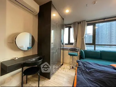Modern bedroom with large windows, stylish furniture, and city view, perfect for urban living.