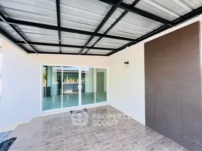 Spacious covered patio with sliding glass doors leading to a modern interior, perfect for outdoor relaxation.