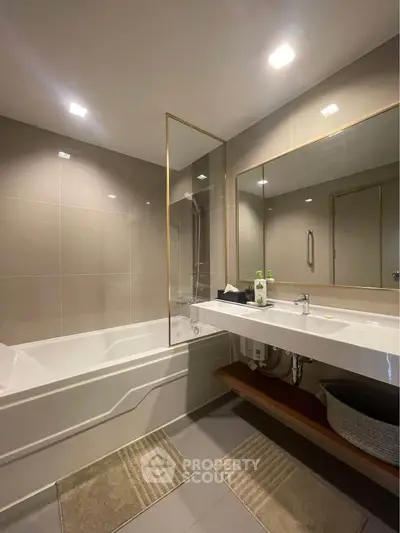 Modern bathroom with sleek design, featuring a bathtub and large mirror, perfect for relaxation.