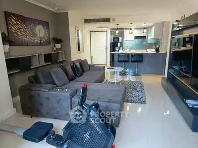 Modern living room with open kitchen, stylish decor, and exercise equipment.