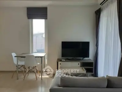 Modern living room with TV, dining table, and large window for natural light.