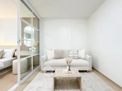Modern living room with elegant decor and neutral tones, featuring a cozy sofa and stylish coffee table.