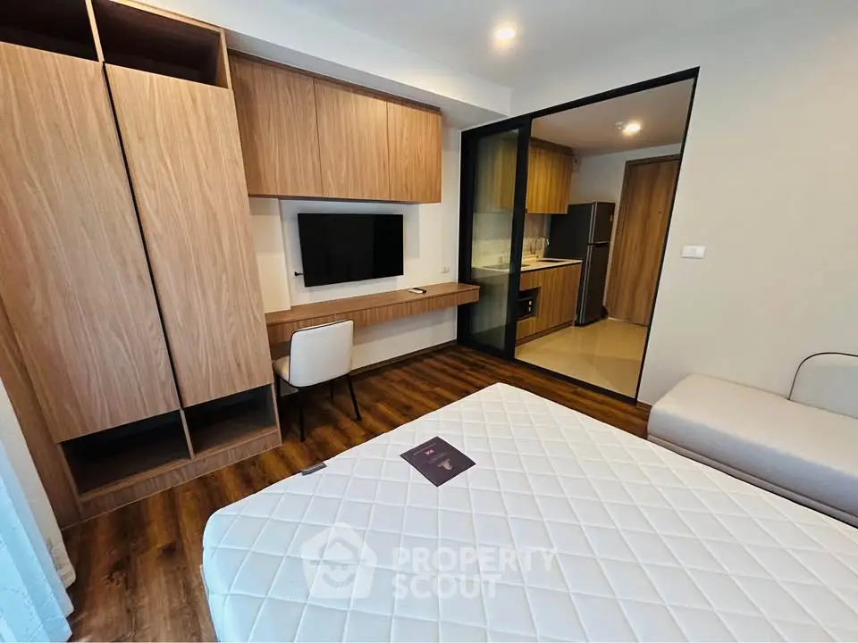 Modern bedroom with integrated study area and sleek kitchen view
