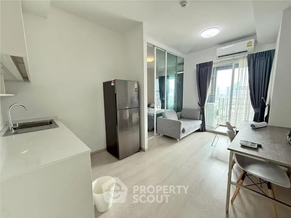 Modern open-plan living room with kitchen and city view balcony in a stylish apartment.