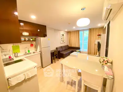 Modern open-layout kitchen and living room with stylish decor and natural light.