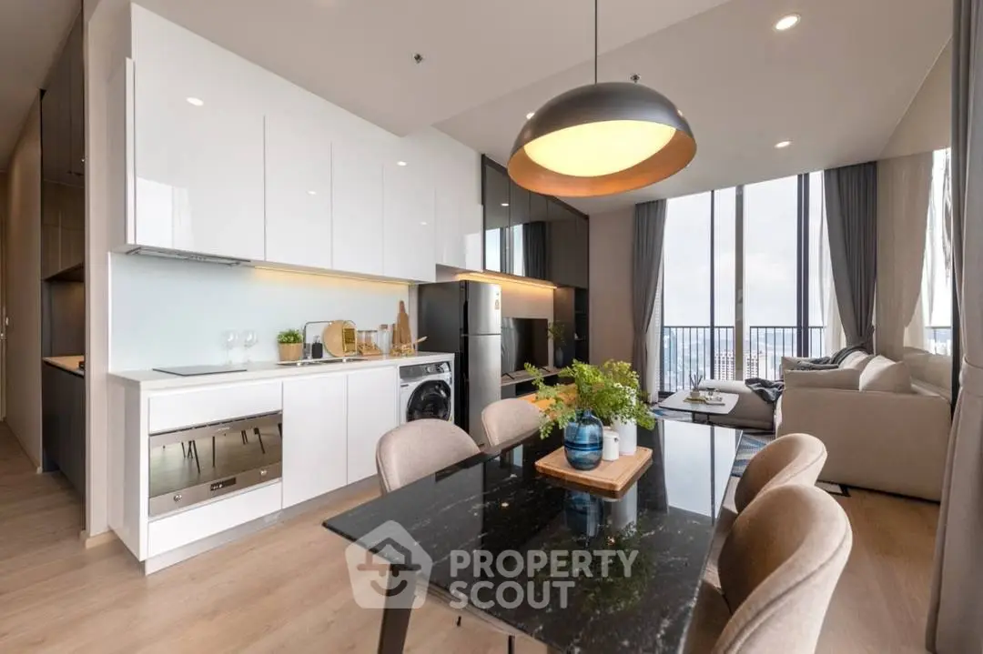 Modern open-plan kitchen and living room with sleek design and city view.