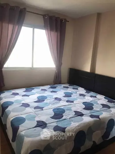Cozy bedroom with large window and stylish curtains, perfect for relaxation and comfort.