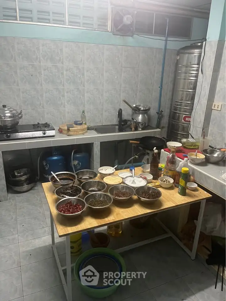 Spacious kitchen with tiled walls, gas stove, and ample counter space for culinary activities.