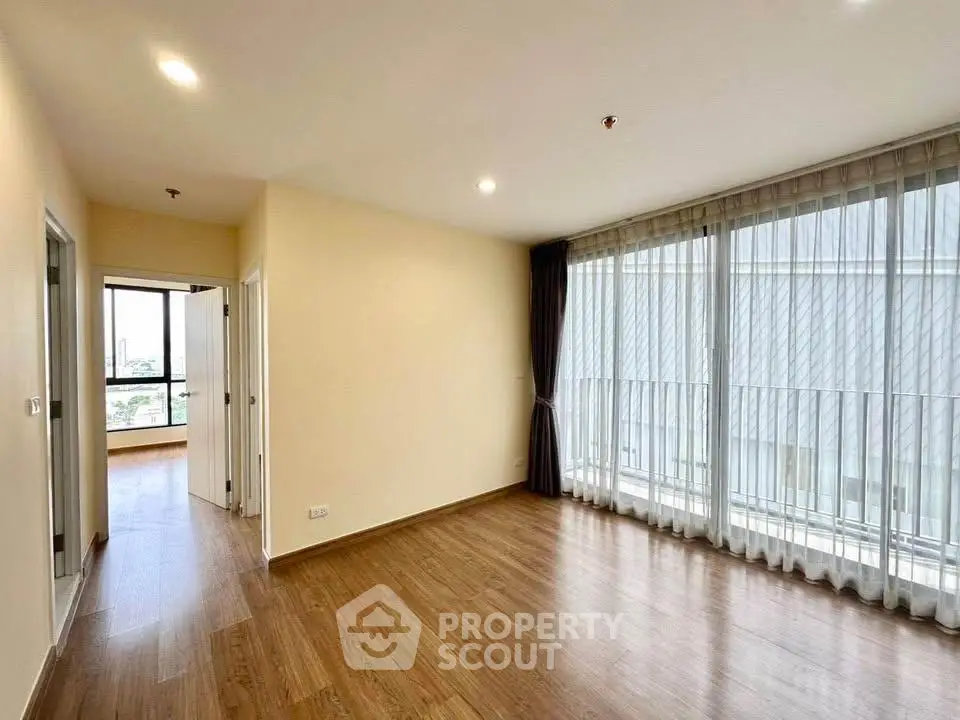 Spacious modern living room with large windows and wooden flooring