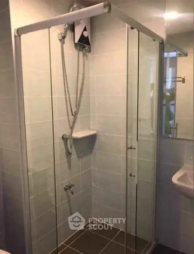 Modern bathroom with glass shower enclosure and sleek tile design.