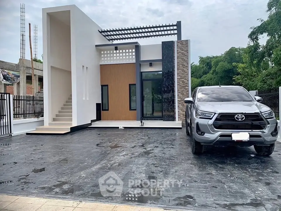 Modern minimalist house exterior with spacious driveway and sleek architecture.