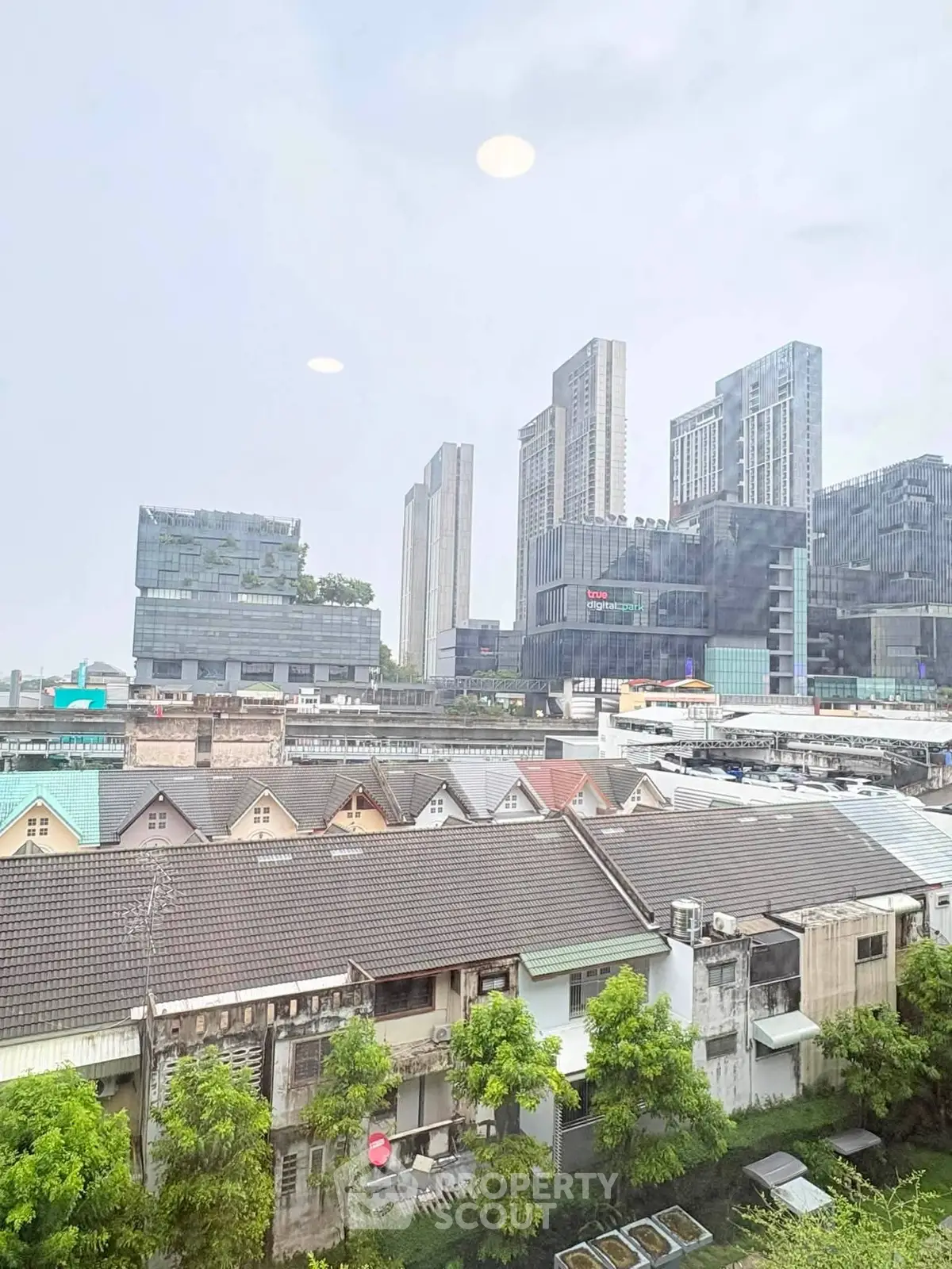 Stunning cityscape view showcasing modern high-rise buildings and charming residential rooftops.