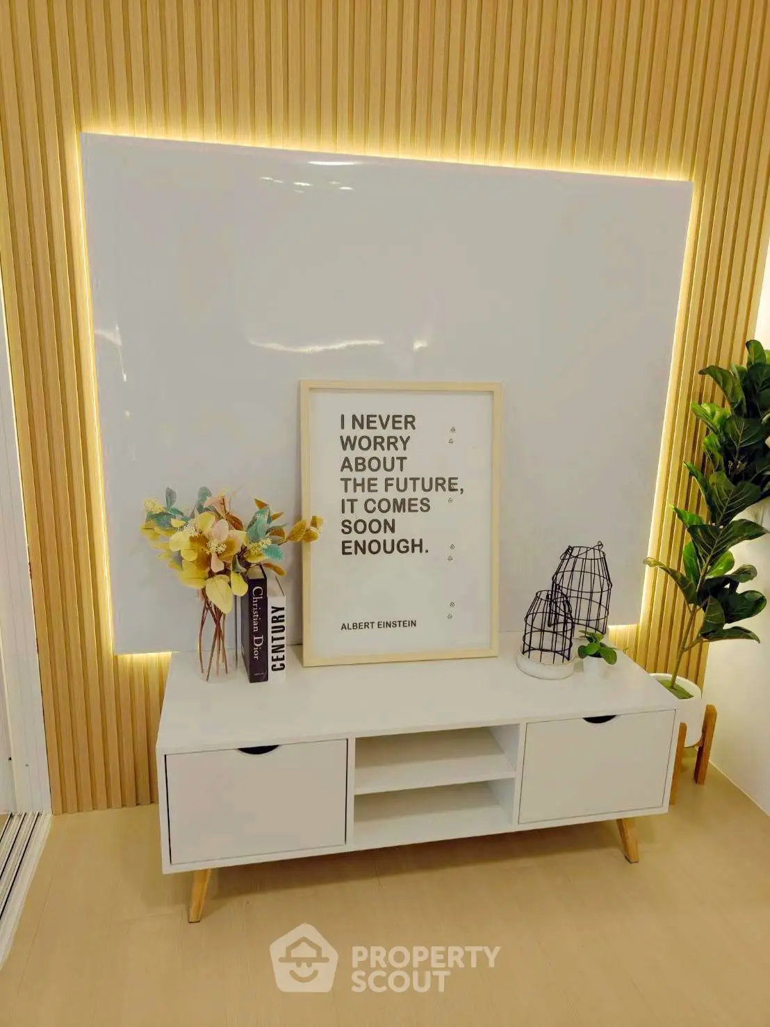 Modern living room with stylish decor and motivational quote, featuring sleek white console and ambient lighting.