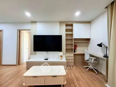 Modern living room with sleek TV setup and stylish workspace