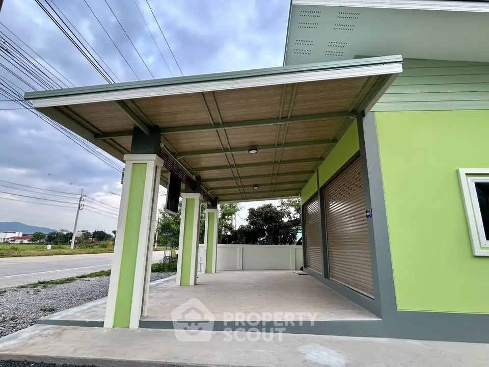 Modern green house exterior with covered carport and spacious driveway