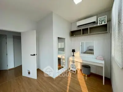 Modern bedroom with stylish decor and natural light, featuring a vanity desk and wall-mounted air conditioner.