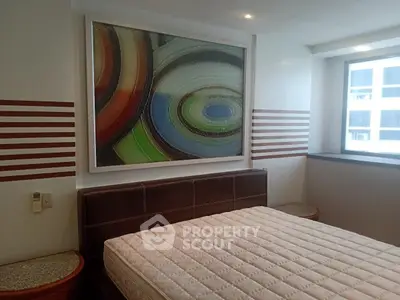 Modern bedroom with abstract art and large window in a stylish apartment.
