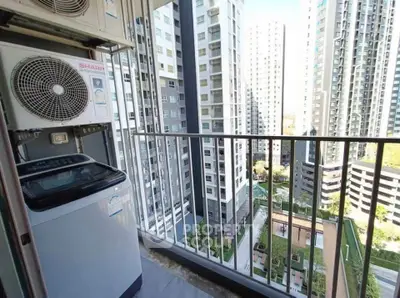 High-rise apartment balcony with cityscape view and outdoor washing machine.