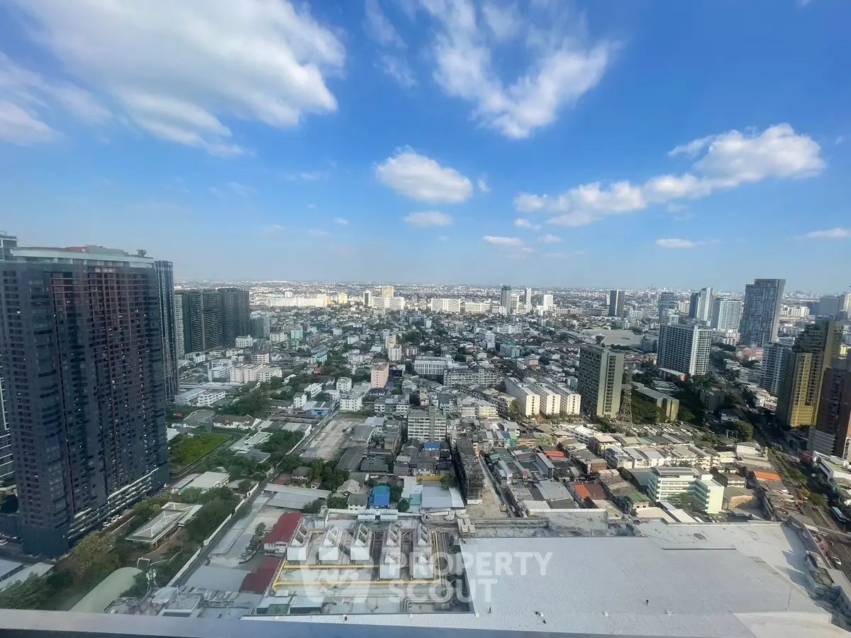 Stunning cityscape view from a high-rise building showcasing urban skyline and blue skies.