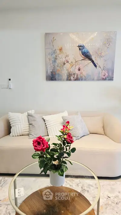 Elegant living room with plush sofa and floral decor, perfect for relaxation.