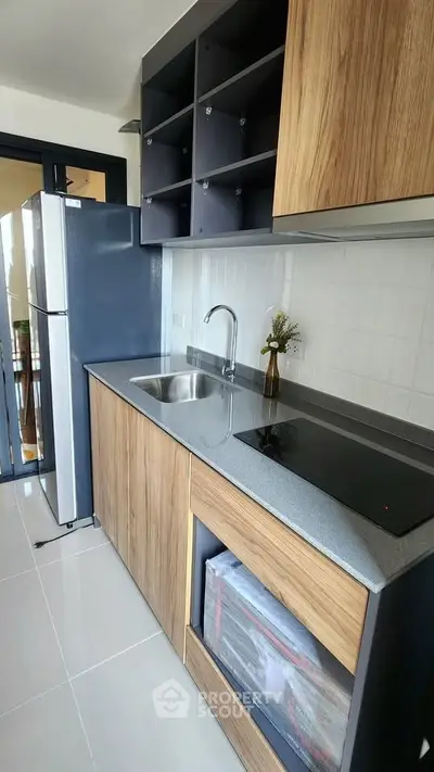 Modern kitchen with sleek cabinets and electric stove in stylish apartment.