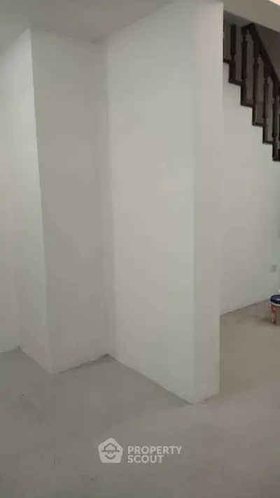 Minimalist interior with white walls and staircase, ideal for modern living space.