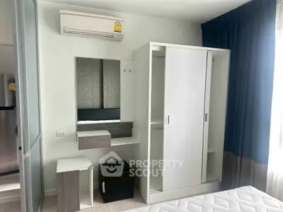 Modern bedroom with sleek wardrobe and air conditioning in a stylish apartment.
