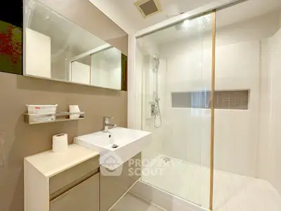 Modern bathroom with sleek shower and stylish sink in contemporary apartment.