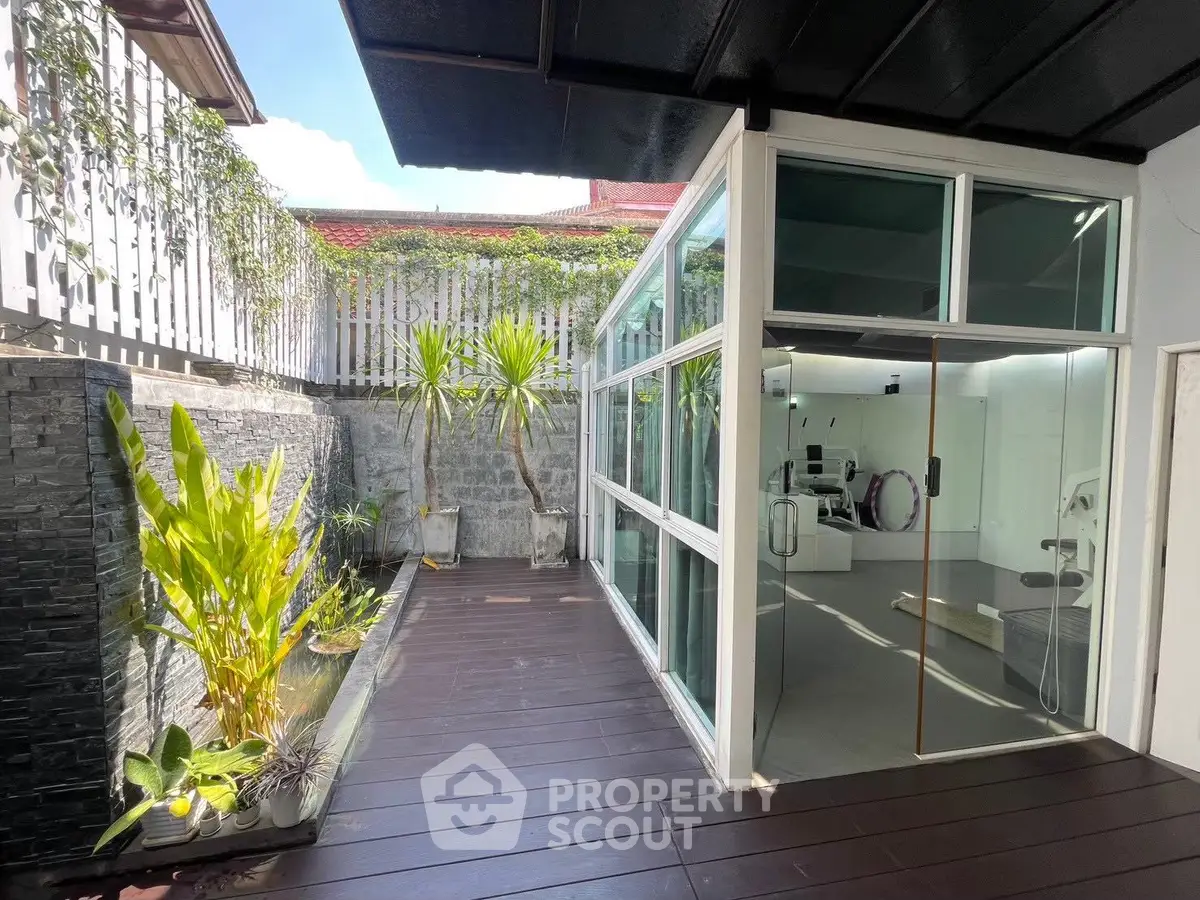 Modern home with sleek glass extension and lush garden patio