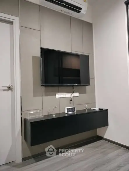 Modern living room with wall-mounted TV and sleek air conditioning unit.