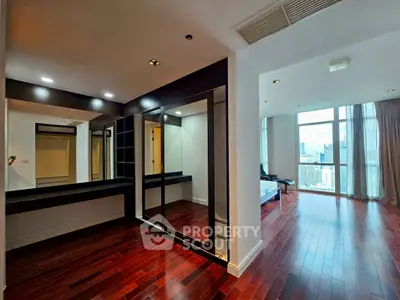 Spacious modern living room with hardwood floors and city view, perfect for urban living.