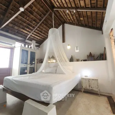 Charming rustic bedroom with wooden ceiling and canopy bed, perfect for a cozy retreat.