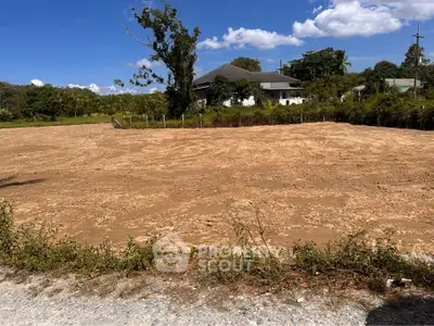 Spacious vacant land with potential for development, surrounded by lush greenery and a serene environment.