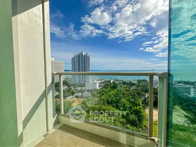 Stunning balcony view of cityscape and ocean under a clear blue sky.