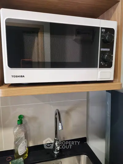 Modern kitchen with sleek microwave and stainless steel sink