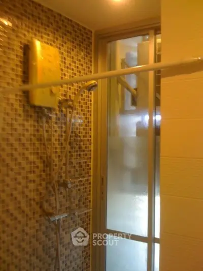 Modern bathroom with glass shower door and mosaic tile wall