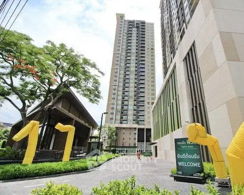 Modern high-rise building with welcoming entrance and lush greenery
