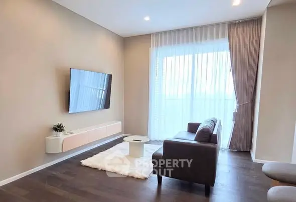 Modern living room with sleek TV setup and cozy seating area.