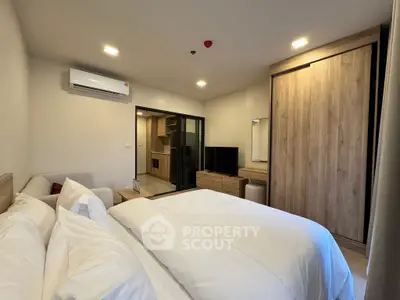 Modern bedroom with cozy bed, wooden wardrobe, and air conditioning in stylish apartment.