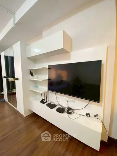 Modern living room with sleek TV unit and wooden flooring, perfect for contemporary urban living.
