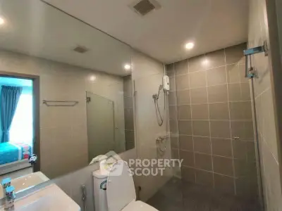 Modern bathroom with sleek fixtures and spacious shower area in a contemporary home.