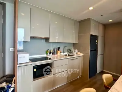 Modern kitchen with sleek cabinets and appliances in a stylish apartment.