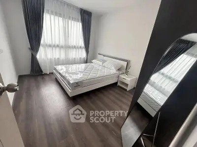 Modern bedroom with sleek design, large window, and stylish flooring.