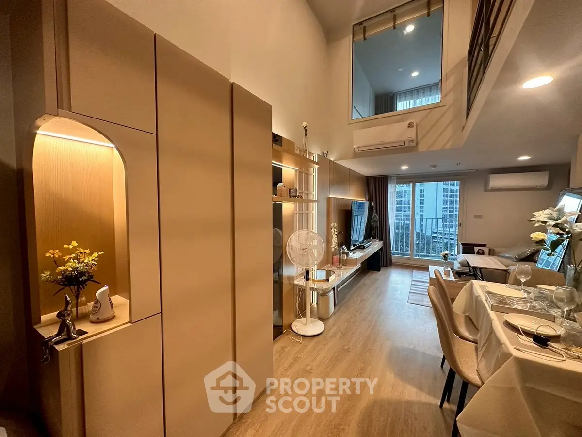 Modern living room with high ceiling and elegant dining area in a stylish apartment.
